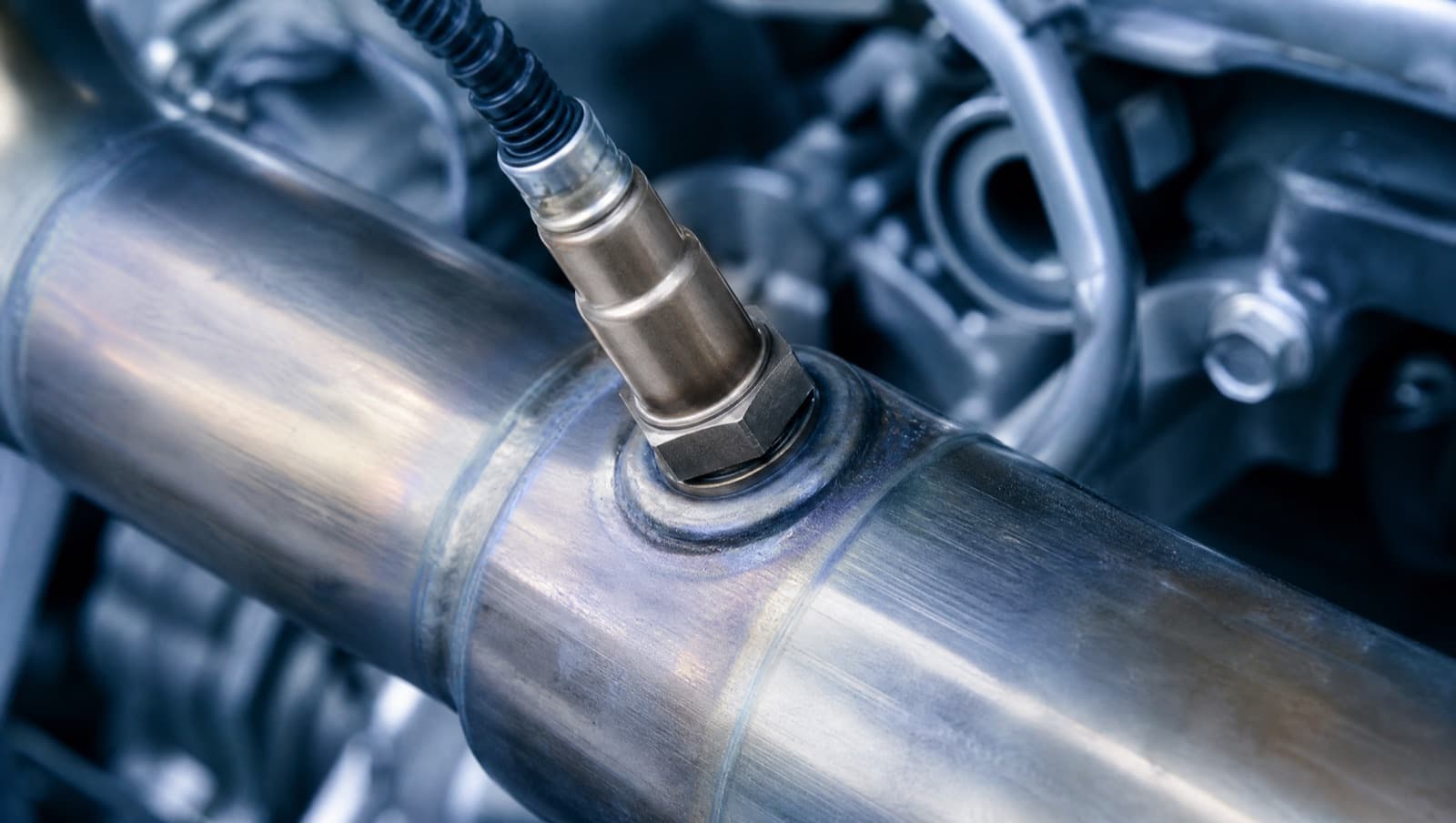 Close-up of an oxygen sensor in a car exhaust pipe